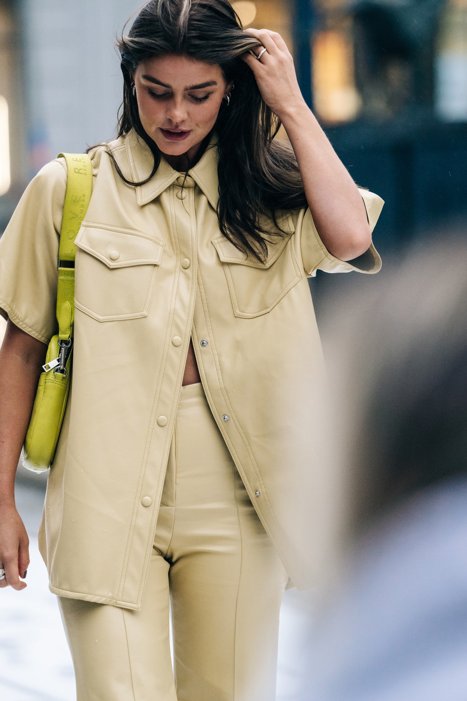 Mujer con conjunto de camisa y pantalón en color beige en el Street Style en la Semana de la Moda Estocolmo...