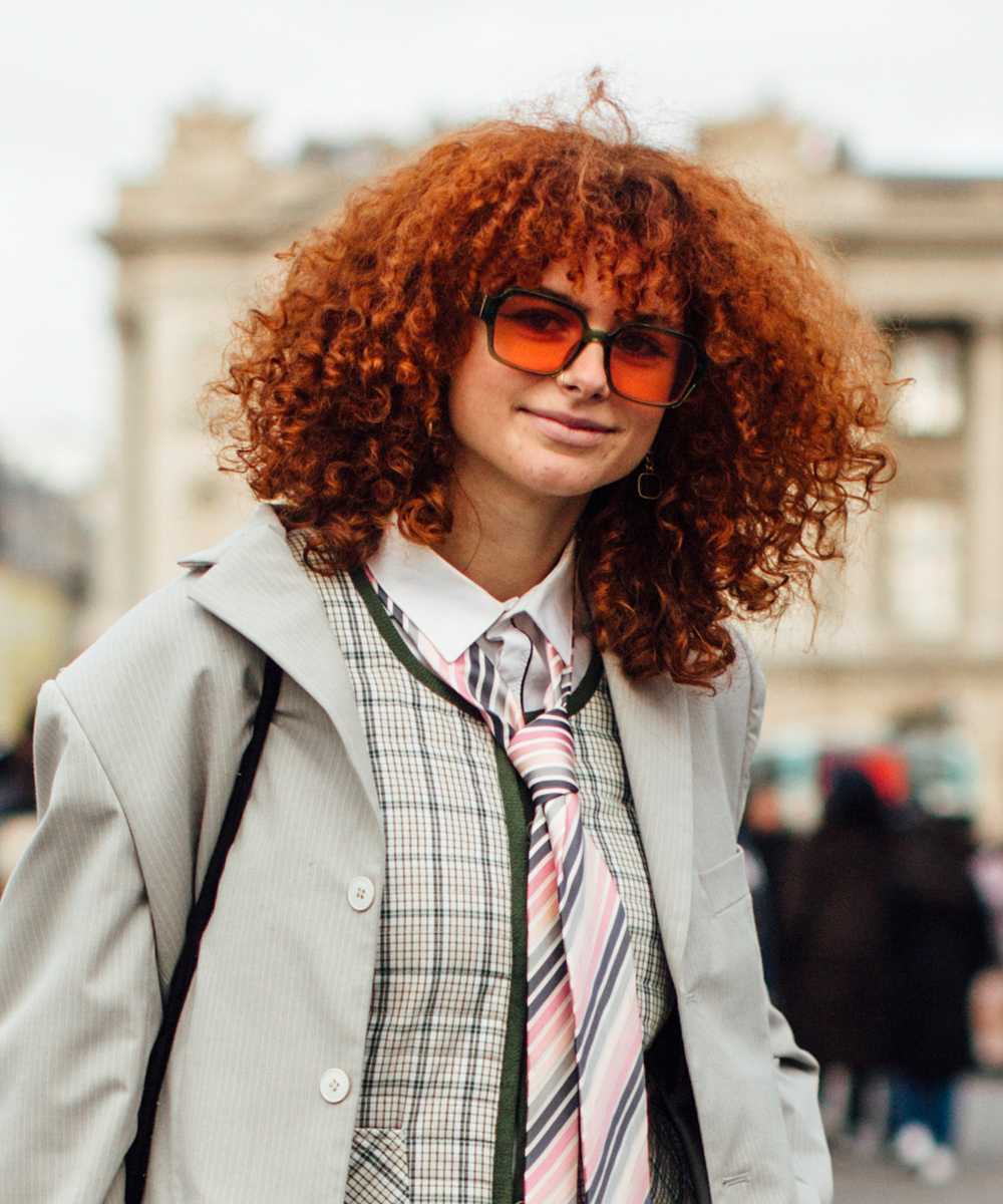 El street style de París nos trae versiones del pelo cobrizo como esta sobre melenas rizadas y a todo color.