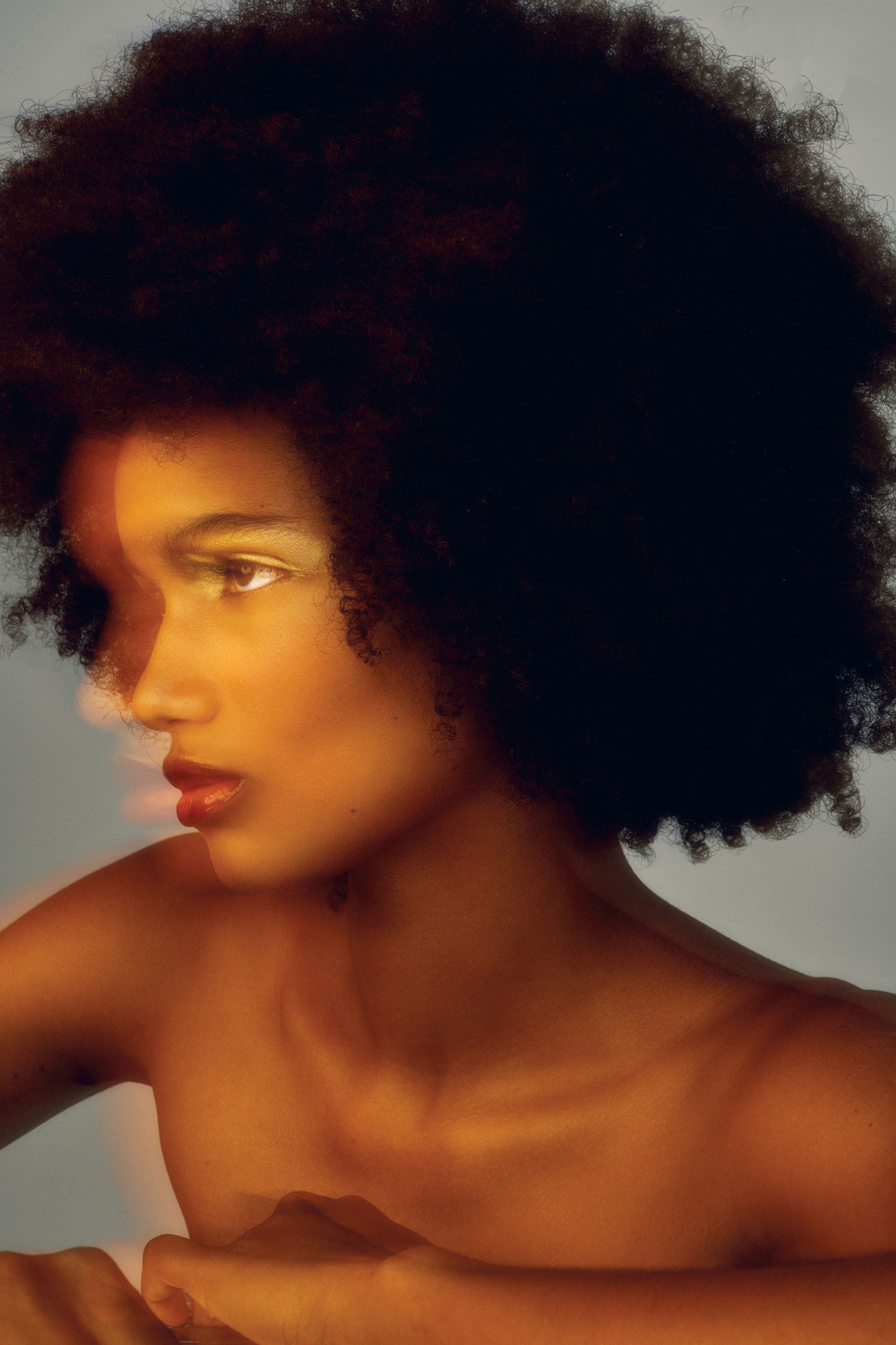 una modelo morena con pelo afro con luces amarillas