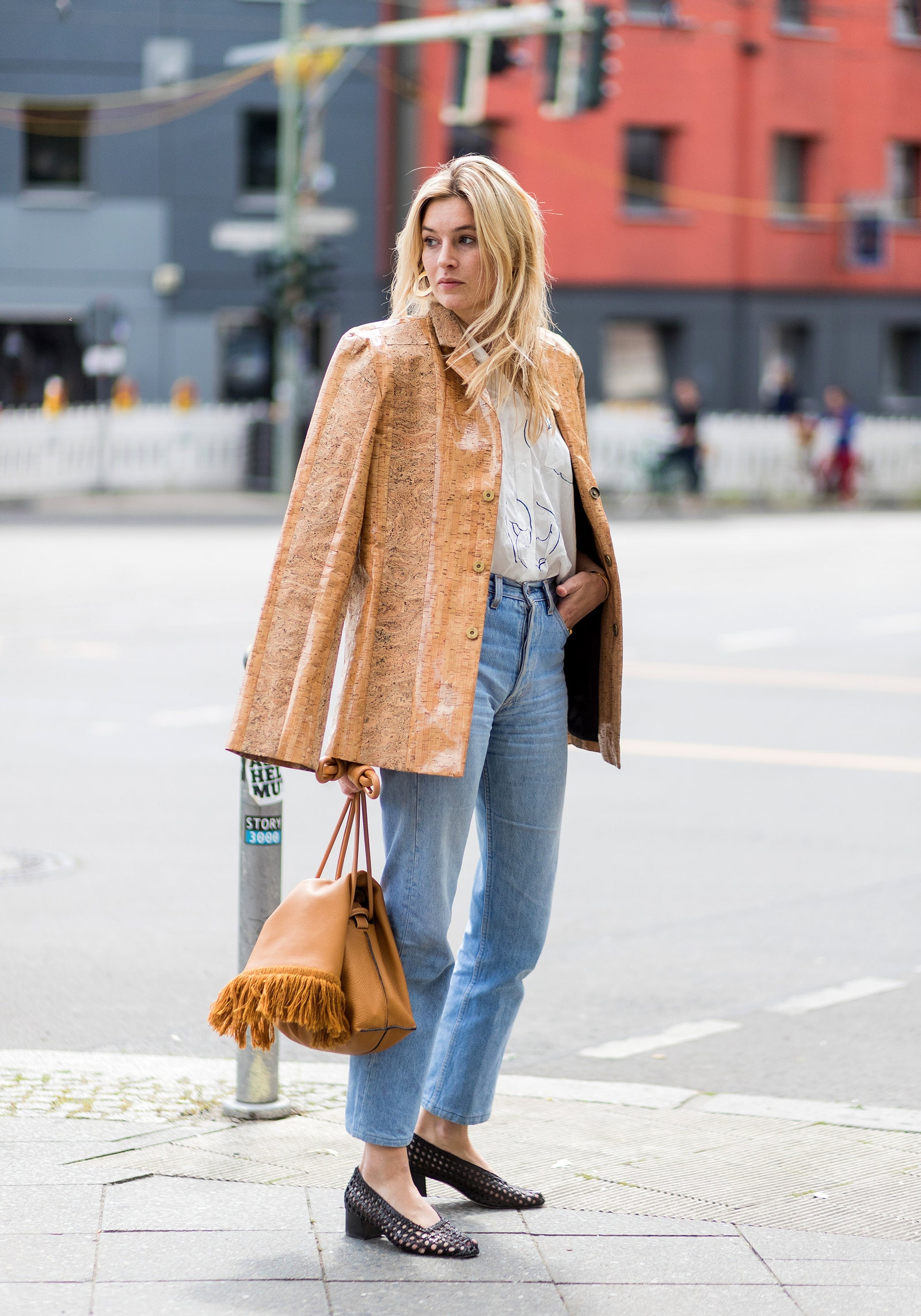 Una chica en el street style de París con unos jeans y abrigo de efecto madera